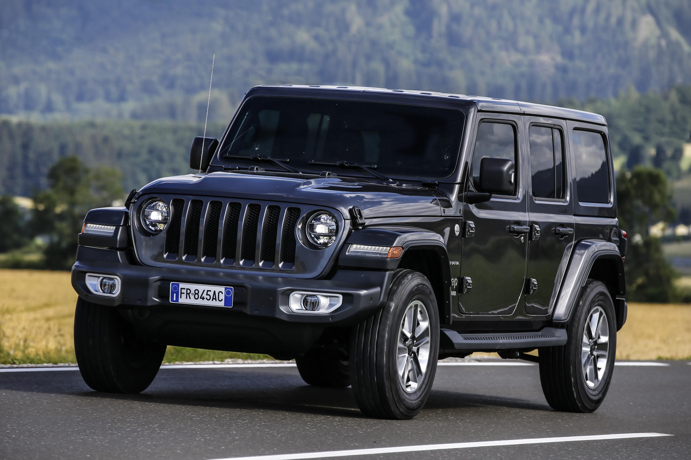Black Jeep Wrangler driving on a road